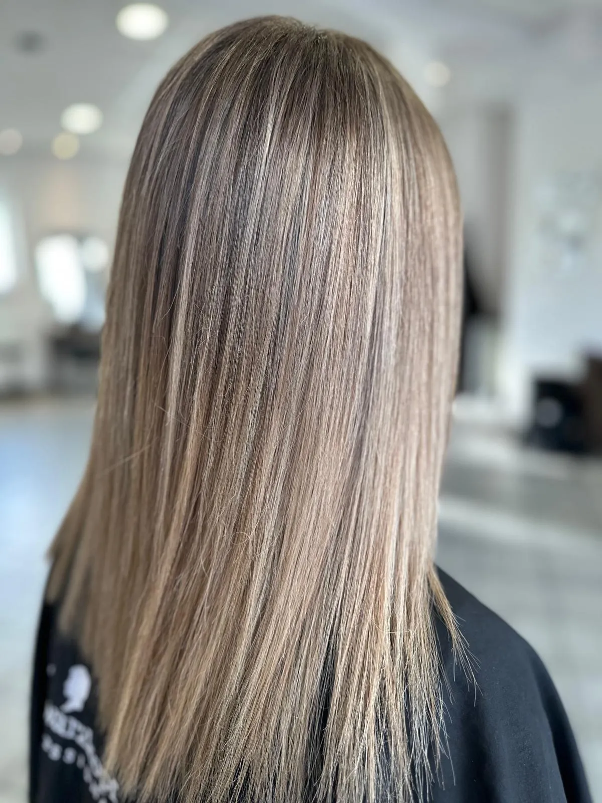 Lange glatte Haare in Asch- und Beigetönen mit weichem Farbverlauf, gemacht im Freestyle Salon in Wolfsburg