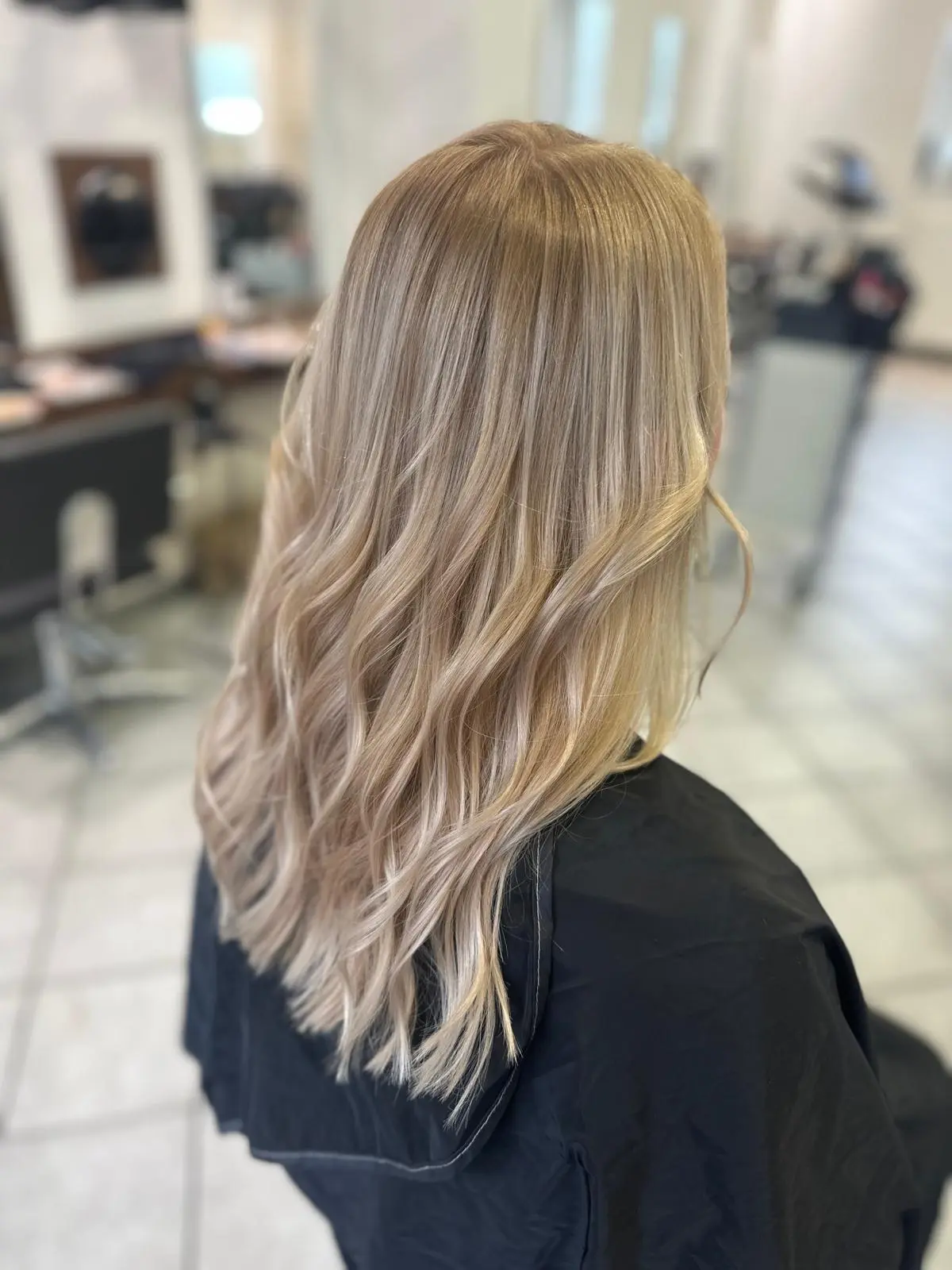 Langes Blond mit silbrigen Spitzen, in weichen Wellen geföhnt